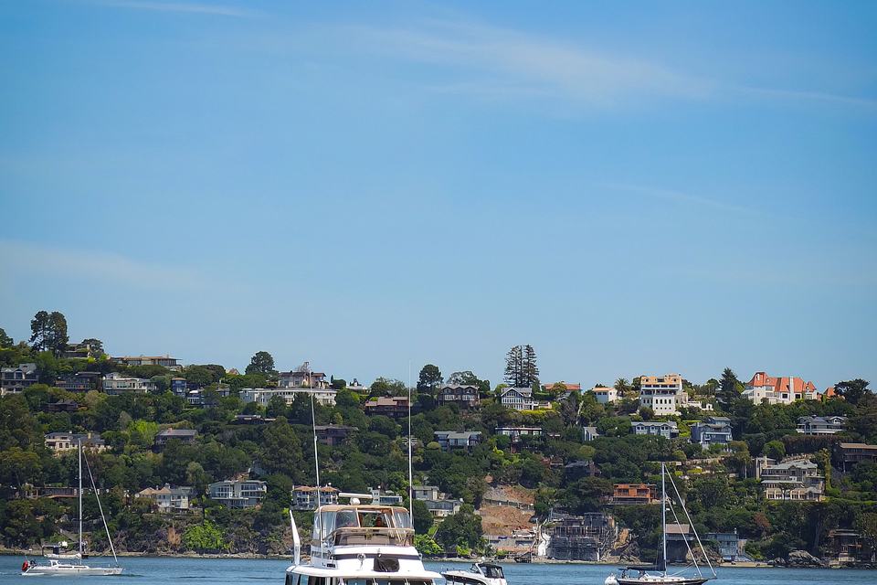 A motor yacht on a calm sea with a coastal town in the background. Illustrative photo.