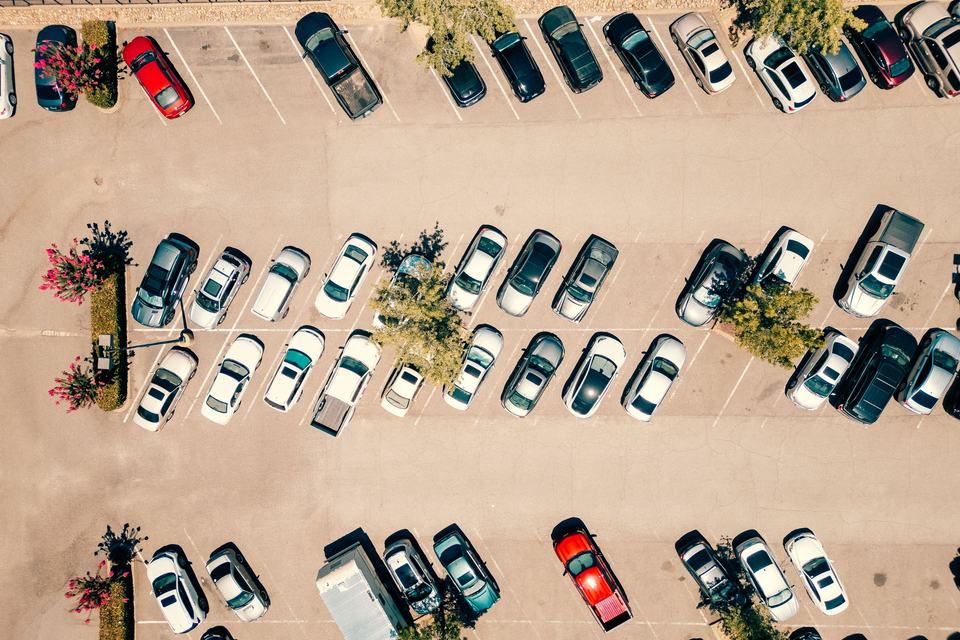 Top view of a parking lot with cars on a sunny day