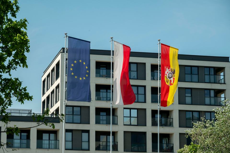Flags of Poland (Polska), EU and Wroclaw (Wrocław) against the background of urban architecture