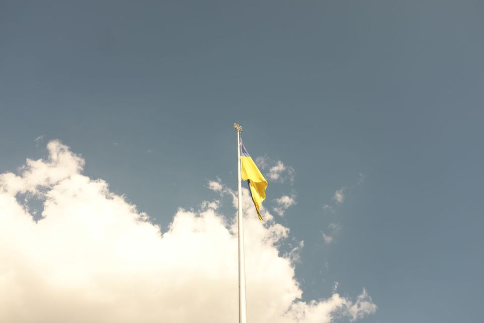 Ukrainian flag against a background of blue sky and clouds