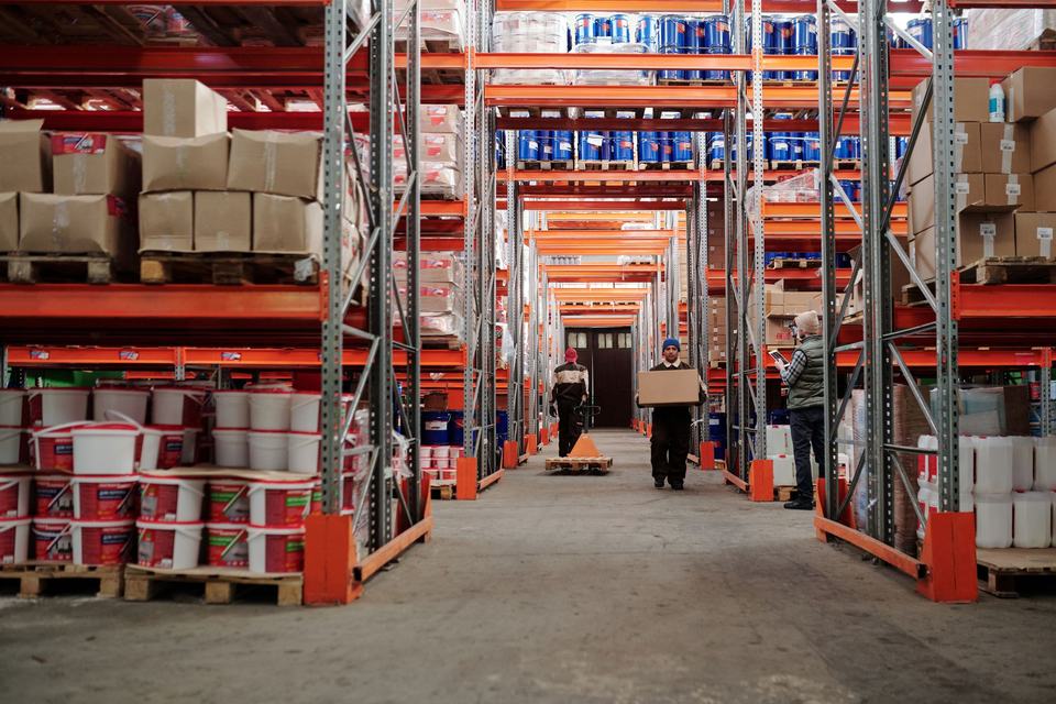 Warehouse room with boxes, racks and employees